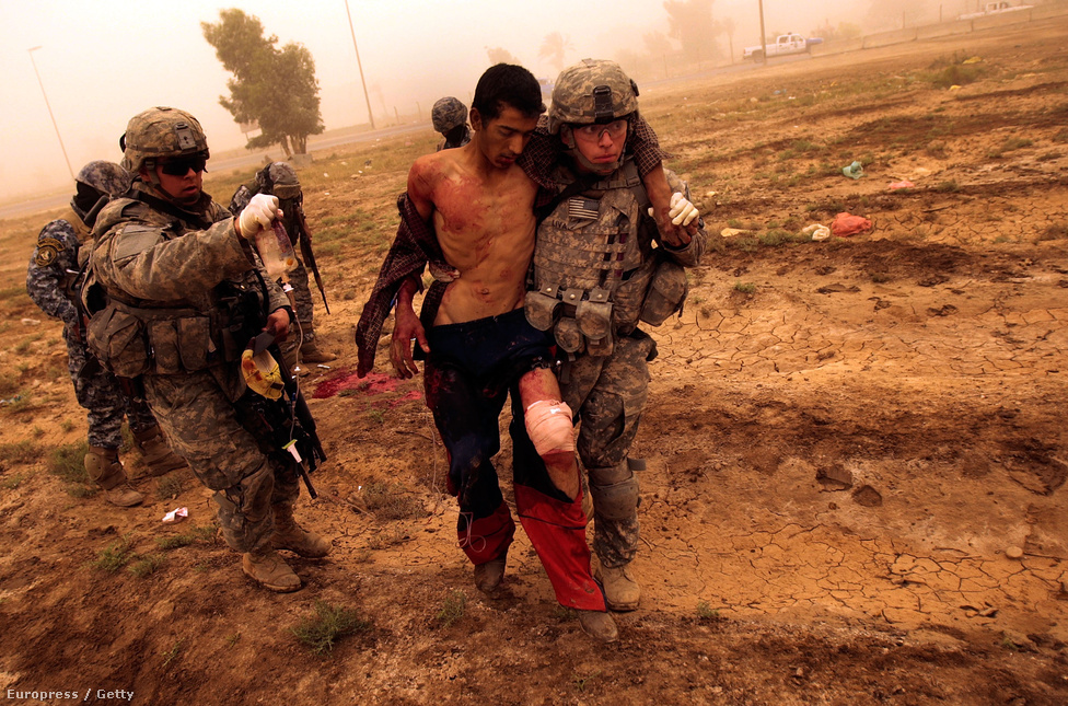 2008. május 6. Amerikai katonák támogatnak egy irakit, aki előzőleg megpróbált elmenekülni előlük, ezért lelőtték. Pedig 2003 októbere visszatekintve boldog békeidő volt. Az igazi problémák csak ezután kezdődtek. Az iraki háború legnagyobb csatája csak fél évvel később kezdődött Faludzsában, a szuniták lakta vidék tán legfontosabb városában. A 2004 április ostrom csak részsikereket hozott. Májustól novemberig egyre fokozódott a lázadók tevékenysége, míg végül a város második, november 7-én kezdődött ostromában végül sikerült megtisztítani Faludzsát. Ennek nagy ára volt, tízezer otthon megsemmisült.