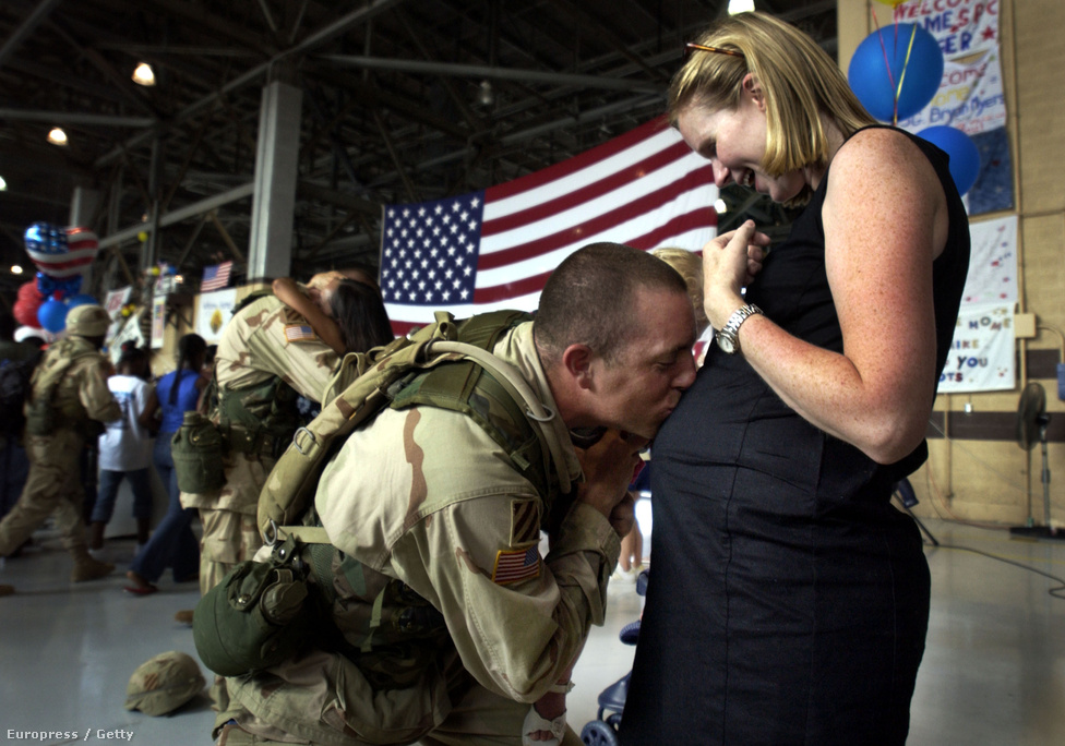 2003. július 16. Az Irakból hazatérő Tory Burgess százados csókot nyom terhes neje, Kathleen pocakjára a georgiai Savannah-ban. 