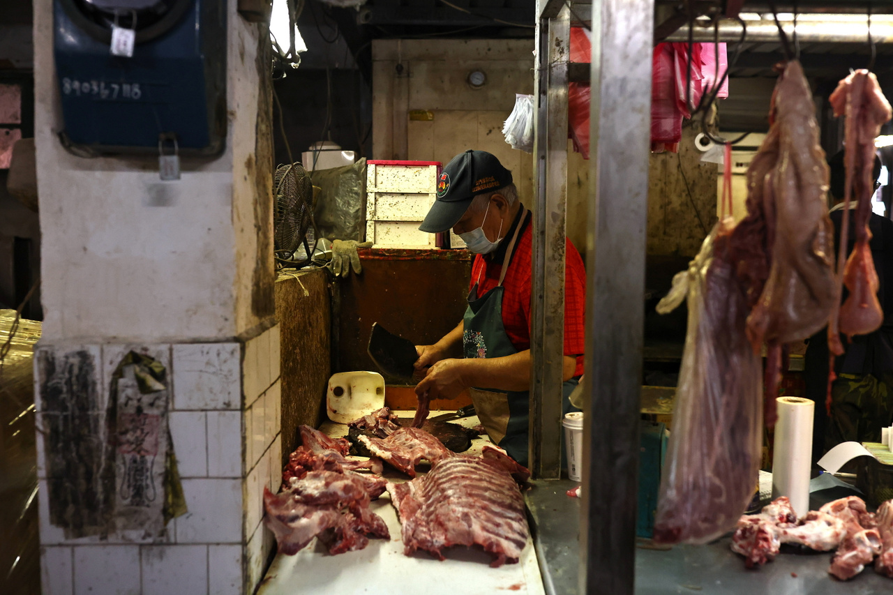 Hentes készít elő húsokat a reggeli nyitás előtt az egyik kinmeni piacon. Kinmen, 2021. október 19.