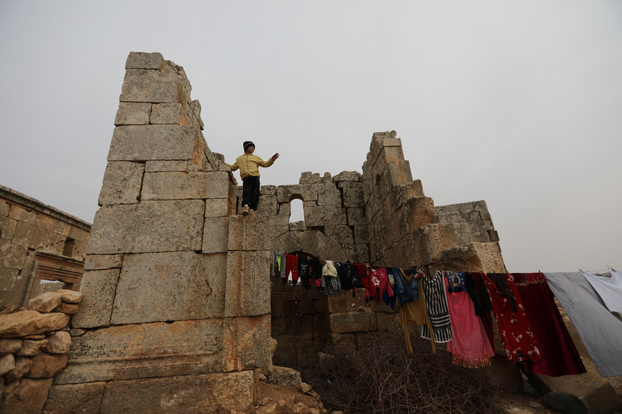 Louay Abu Al-Majd (11) áll egy épületmaradványon, alatta a megtisztított ruhák szárítására használt kötél.