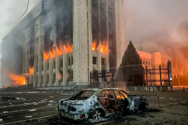 Egy leégett autó látható a polgármesteri hivatal épülete mellett 2022. január 5-én