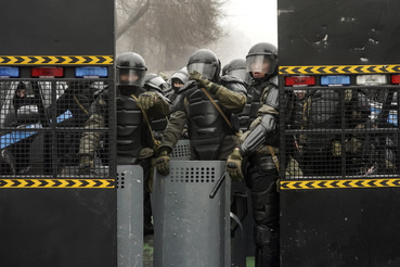 Rohamrendőrök barikádot emeltek egy utcán, hogy feltartóztassák a tüntetőket Almati központjában 2022. január 5-én
