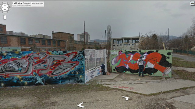 Grafitis éppen festi a falat, a kép bal oldalán láthatjuk a fesékesflakonokat is.