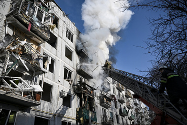 Tűzoltók dolgoznak egy légi csapás helyszínén Csuhuiv városában 2022. február 24-én
                        