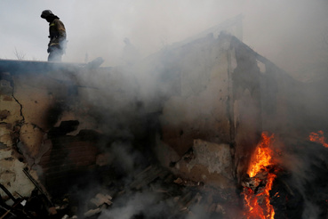 Tűzoltók dolgoznak egy kigyulladt házban Donyeckben 2022. február 28-án