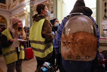 Egy Ukrajnából menekült nő hátizsákban a macskájával a lengyel Przemyśl pályaudvarán 2022. március 1-jén