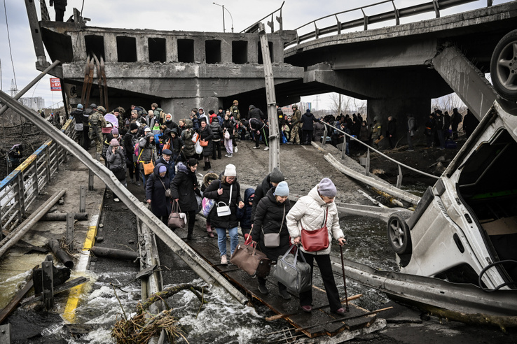 Egy lerombolt híd maradványai között kelnek át az emberek Irpiny városában 2022. március 5-én