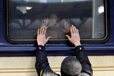 Egy férfi egy evakuációs vonat előtt a kijevi pályaudvaron 2022. március 4-én