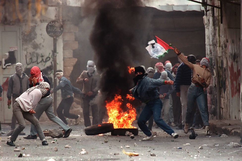 Palesztin tüntetők kövekkel dobálják 1988. január 29-én Nablusban az izraeli katonákat. Az 1987-ben kirobbant első intifáda (az izraeli megszállás elleni palesztin felkelés) alatt az izraeliek ellen tiltakoztak a palesztinok a megszállt területeken. A Hamász is az első intifáda alatt jött létre. A palesztin csoportokat is egymás ellen fordító erőszakban több ezren haltak meg, míg 1993-ban aláírták az oslói békeegyezményeket.
