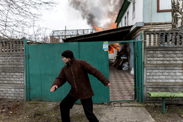 Egy férfi elhagyja égő házát Irpinyben 2022. március 6-án