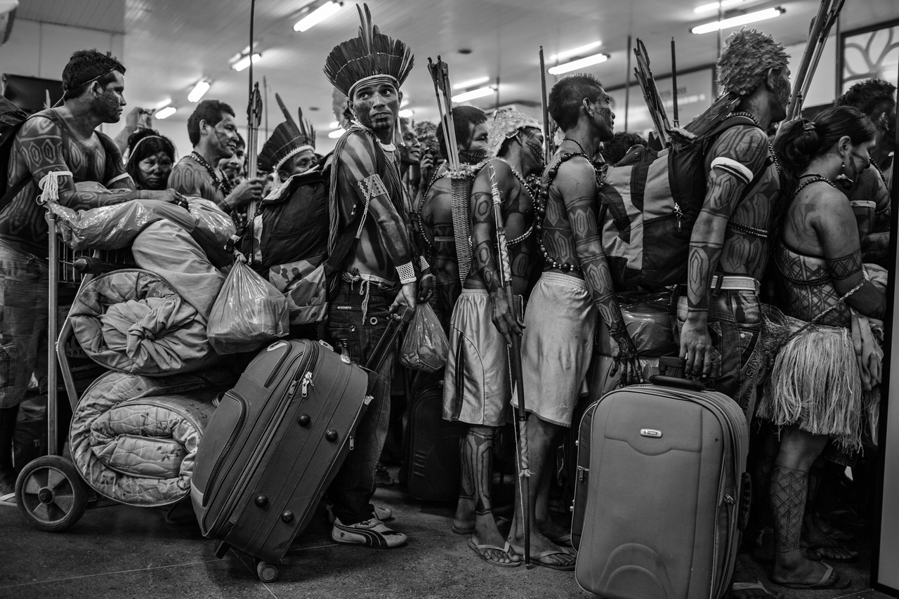 A Hosszú távú projekt kategória globális fődíjasa: Amazóniai disztópia (Dél-Amerika): Amazóniai őslakosok egy csoportja a munduruku törzsből éppen beszállásra vár Altamira repülőterén a brazil tagállamban, Parában, miután előzőleg tüntettek a Xingu folyónál tervezett Belo Monte gát építése ellen. Most pedig a brazil fővárosba tartanak, hogy átadják követeléseiket a kormánynak. Az Amazonas mentén mintegy 350 őslakos indián csoport él, a mundurukuk az Amazonas egyik mellékfolyója mentén élnek. A fotó 2013 júniusában készült.