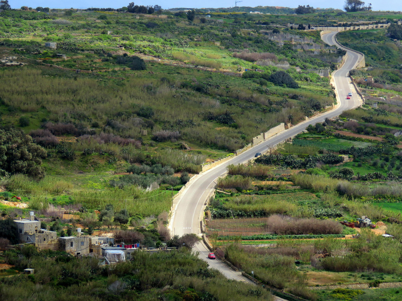 Málta sűrűn lakott, ebből következően úthálózata is sűrű. Az EU-ba történt belépés óta eltelt években sokat javult az utak minősége, ám a rengeteg autó miatt a csúcsidőszakokban például Vallettában és környékén rendszeres az erős forgalom, és előfordulnak dugók. A kisebb vidéki utak is már aszfaltosak többnyire, ám gyakran csak egy sáv szélességűek, és olykor magasra rakott terméskő falak között vezetnek, így a gyors közlekedésre alkalmatlanok. A sikátoros óvárosokban sok a keskeny, egyirányú utca, ami tovább bonyolítja a közlekedést. És akkor még nem beszéltünk a kanyarokról, pedig Máltán jóformán csak kanyarokból áll a teljes úthálózat… Képünkön: tipikus vidéki országút Gozo szigetén.