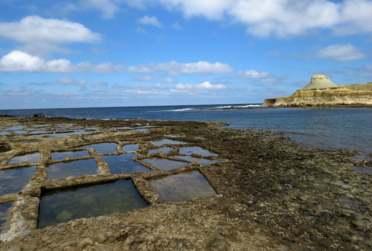 Ipari termelés napenergiával: a sziklába vájt sólepárló medencéket ma is működtetik a Xwejni-öbölben, Gozón. A Nap- és kézműves tengeri só legfőbb vásárlói ma már a turisták.