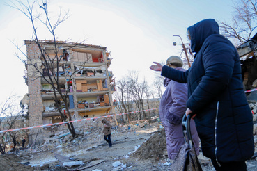Lakók egy támadásban megsérült épület előtt Kijevben 2022. március 18-án