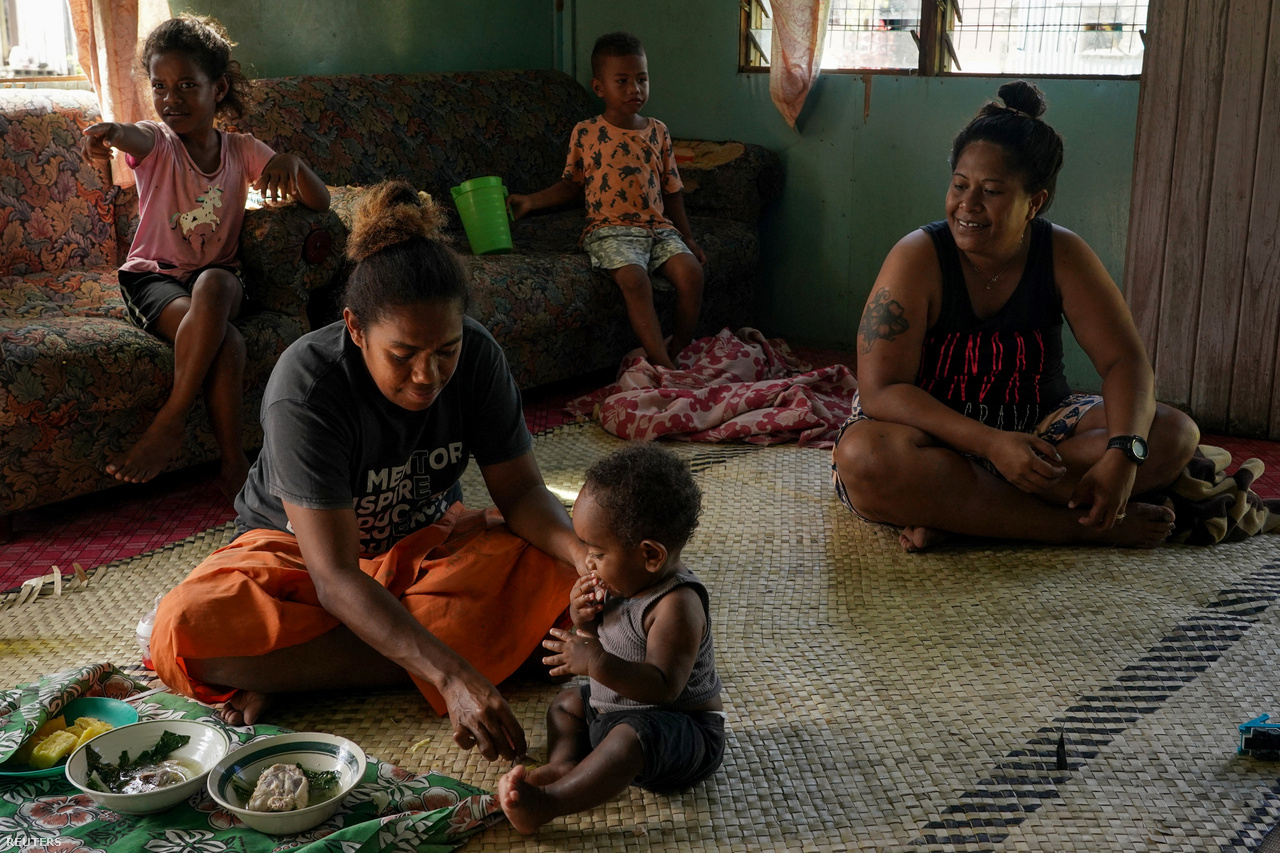Amy Lawai alimenta a Jo Surwai, de 9 meses, con su familia en Fiji el 13 de julio de 2022