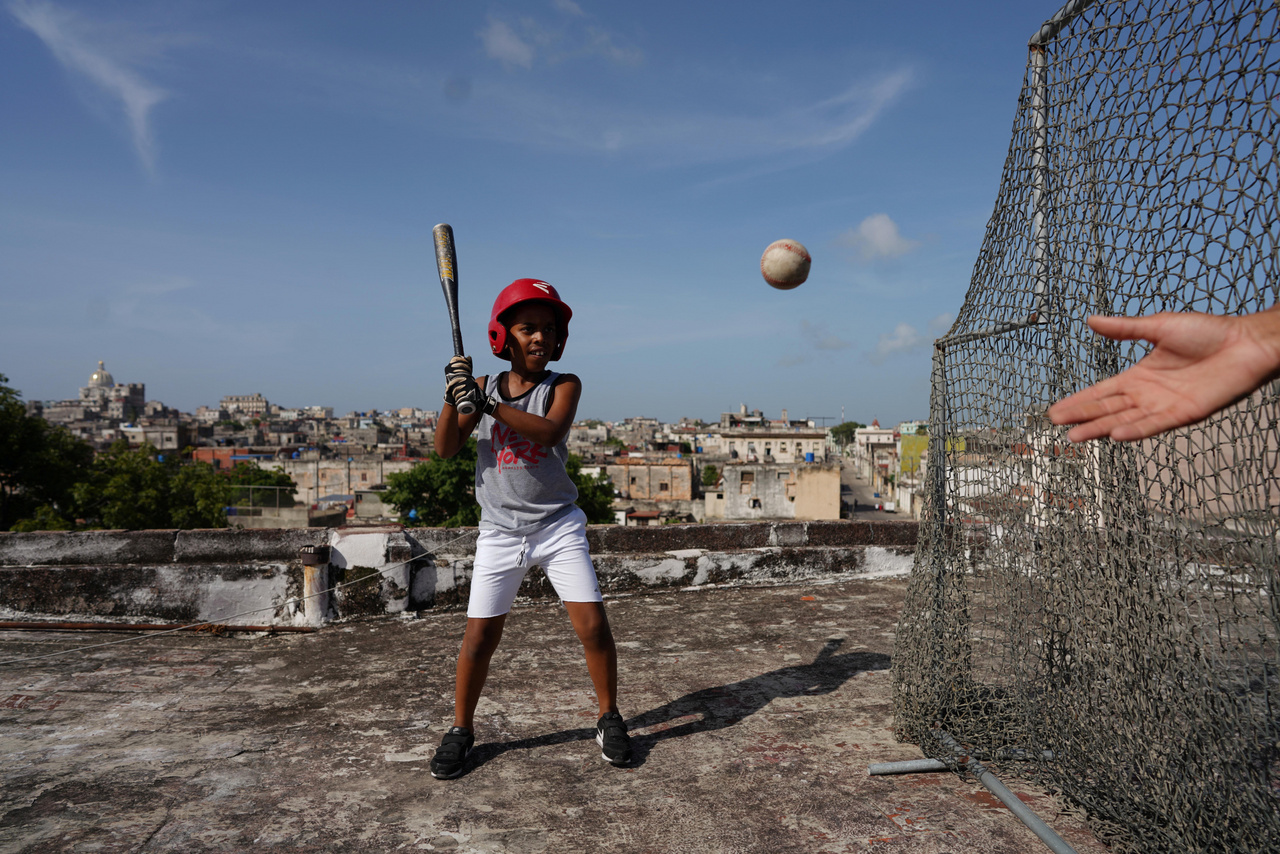 Kevin Kindelan 8 éves baseballrajongó gyakorol az édesapjával házuk tetején Havannában, Kubában 2022. június 14-én. Kindelan azt mondja, hogy a kubai nemzeti bajnokságban szeretne játszani.
