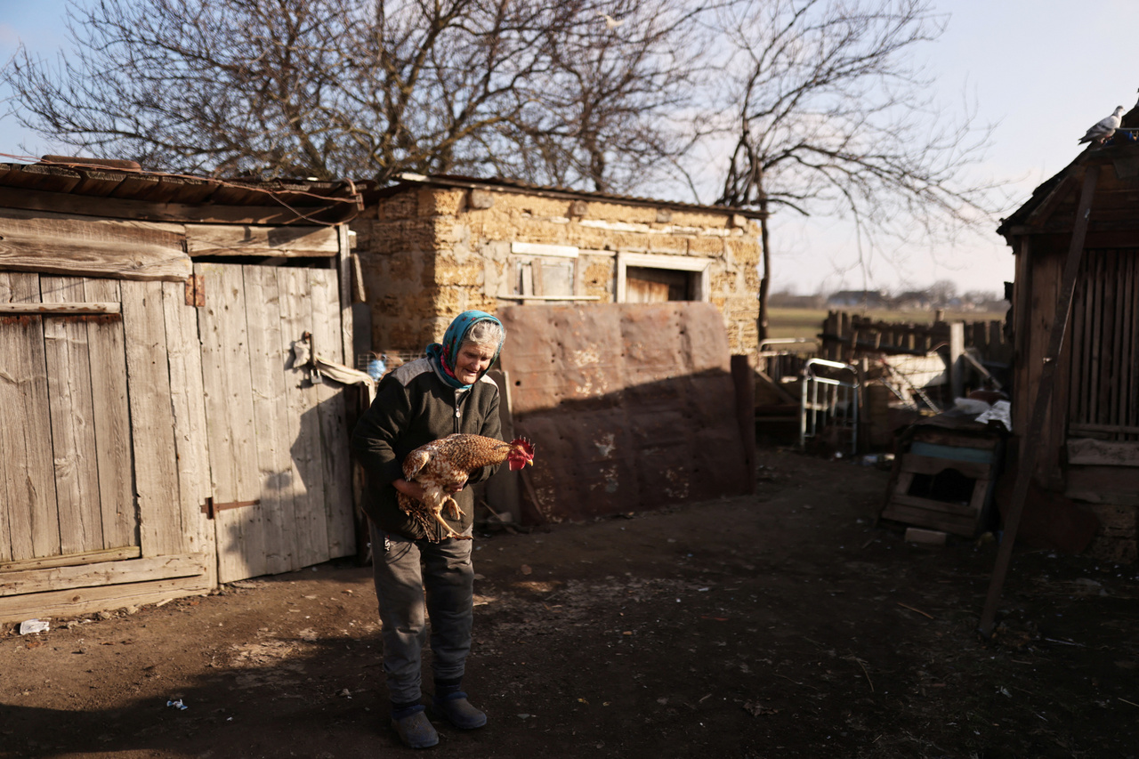 A 76 éves Tetjana, akinek házát ősszel érte találat és megsemmisült, egykori házuk udvarán Poszad-Pokrovszkében, Herszontól 35 kilométerre. 2023. január 26-án.  