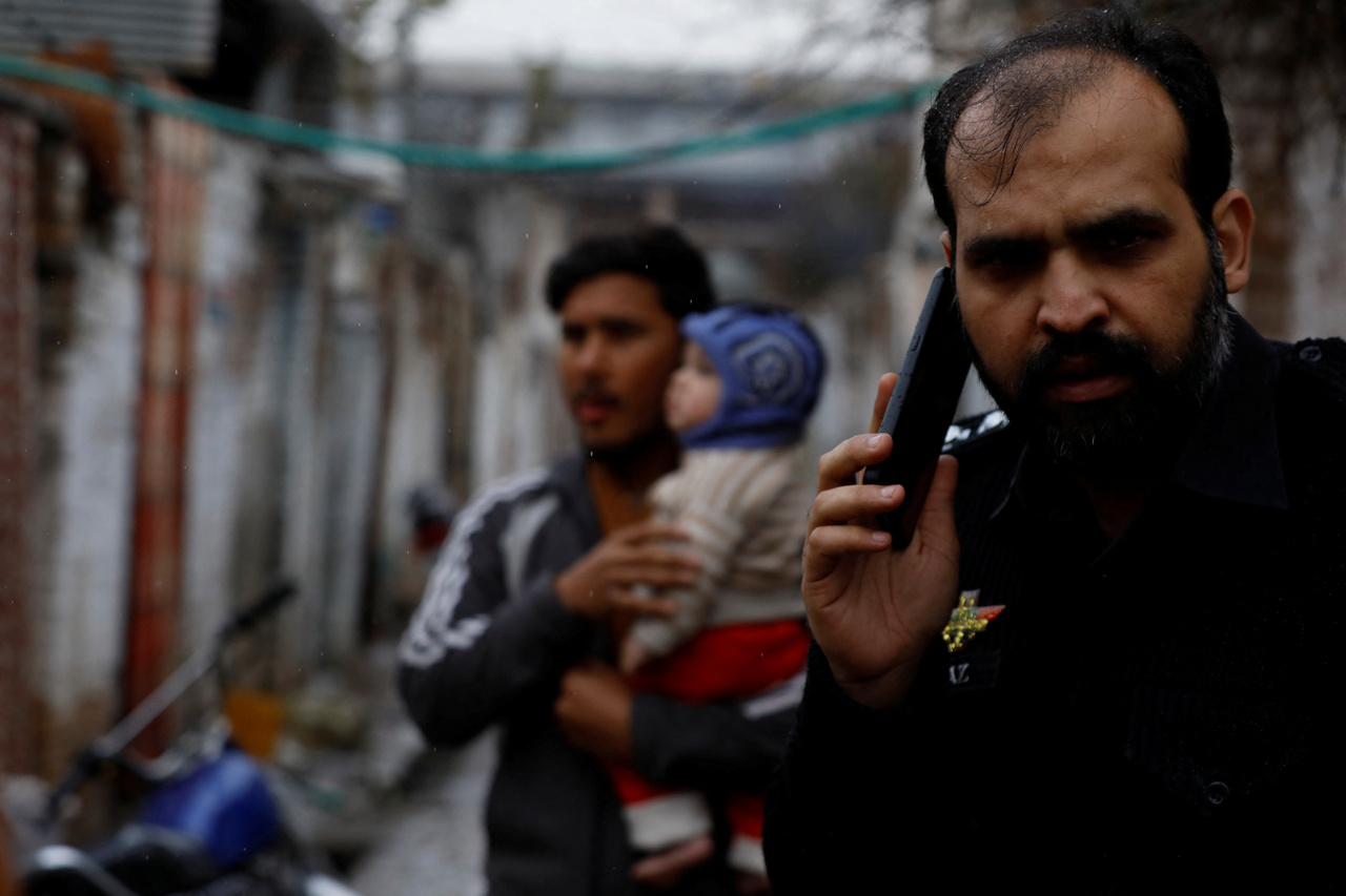 Rendőrtiszt telefonál a pakisztáni Pesavár egyik utcáján.