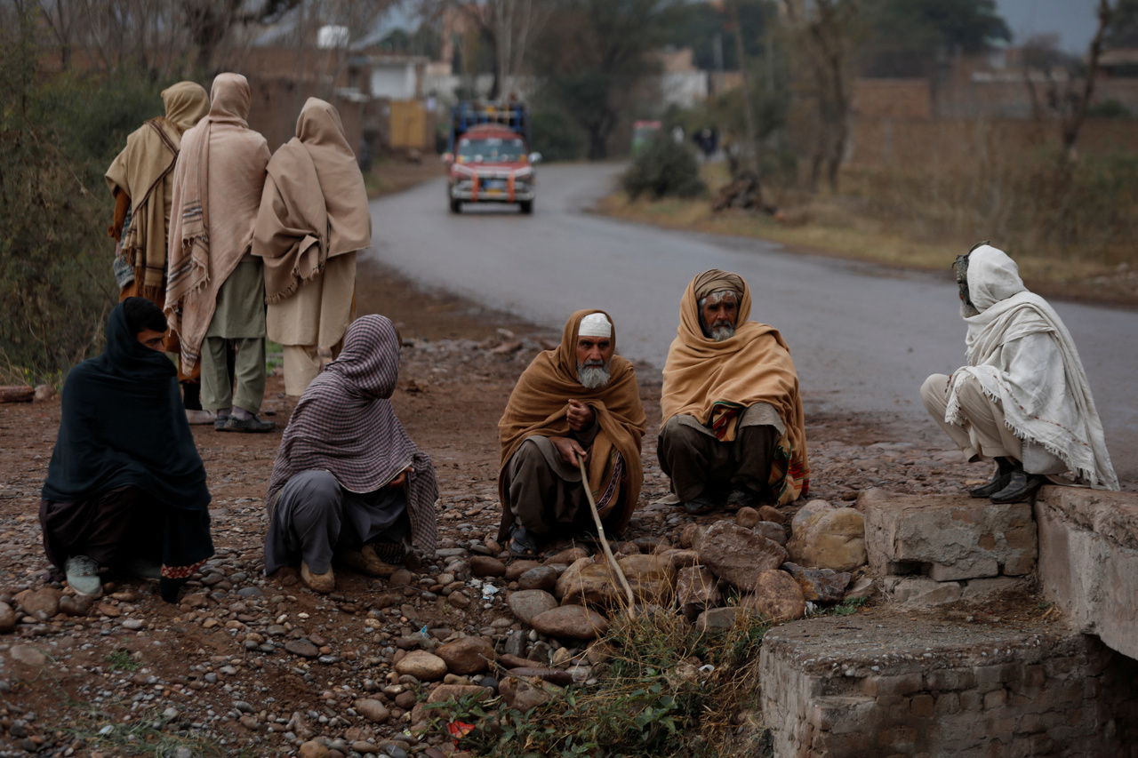 Helyiek ülnek és beszélgetnek egy út mentén a Pesavár külvárosában lévő Sarband körzetben.