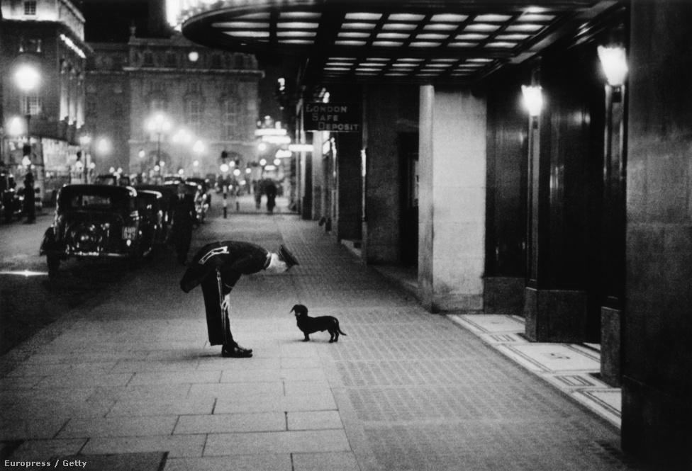 1938. Londíner és tacskó beszélgetnek a Piccadilly Circus egyik szállodája előtt.