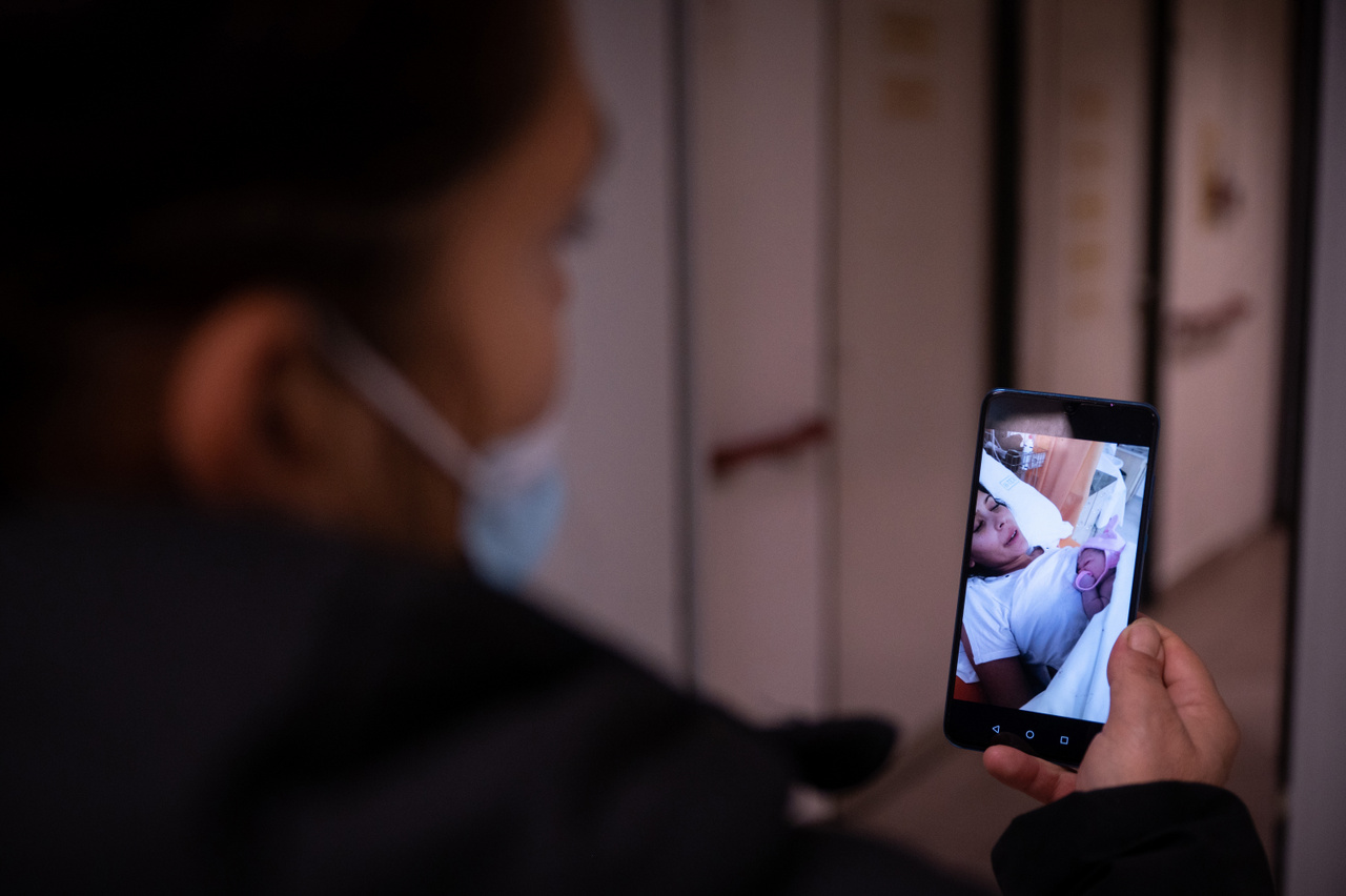 Bogi a szülőszoba előtt videóhívásban mutatja meg hetedik unokájának fotóját a rokonságnak.