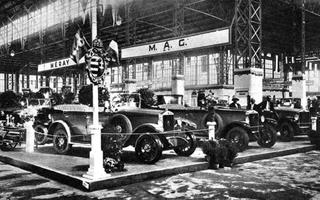 Nyitás előtt a Nemzetközi Autókiállításon,
                        1927. június 4-én. A jól bevált Magomobilok a standon is háttérbe szorultak az új Magosixek mellett. Balra megmunkált fődarabok láthatók, jobbra (nyakkendővel) Szigeti Andor, a MÁG szerkesztési osztályának vezetője.
                        (Fotó: Pesti Napló 1927)