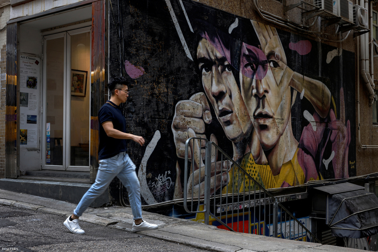 Egy férfi sétál a Bruce Lee-t ábrázoló graffiti mellett a hongkongi Sheung Wanban 2023. május 5-én
