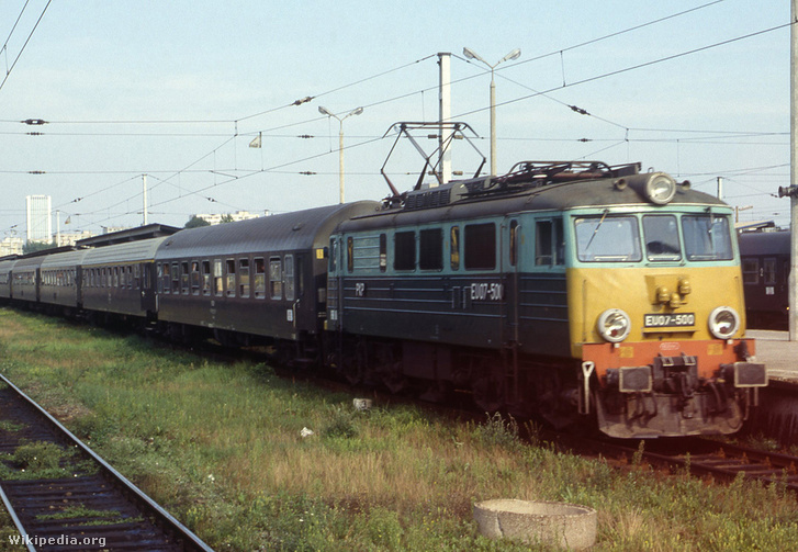 Tipikus távolsági gyorsvonat a 90-es évek közepén a Varsói pályaudvaron. A vonat élén egy EU07-es Siódemka (Hetes) becenevű, univerzális villanymozdony, ami a PKP Szilije. A mozdonytípusból 1965 és 1994 között 489 darabot gyártottak a lengyel vasútijármű gyártó vállalatok