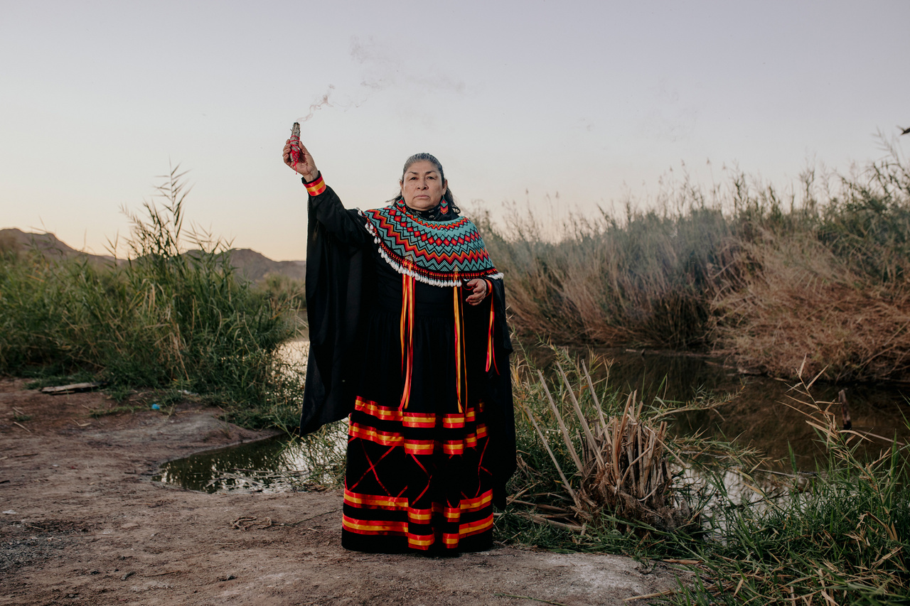 Antoni Torres Gonzalesc tradicionális cucapah gyöngyös nyakdíszt visel, miközben imádkozik a Colorado
                        folyó partján. Attól tart, hogy a víz eltűnésével és a halállomány fogyatkozásával a cucapah kultúra is eltűnik,
                        mivel az ott lakók elhagyják a falvakat, hogy a városokban találjanak munkát. Ellensúlyozásaképpen a
                        hagyományos mesterségek ismereteit adja át a fiatal generációknak, hagyományos szertartásokat szervez és
                        konferenciákon vesz részt.