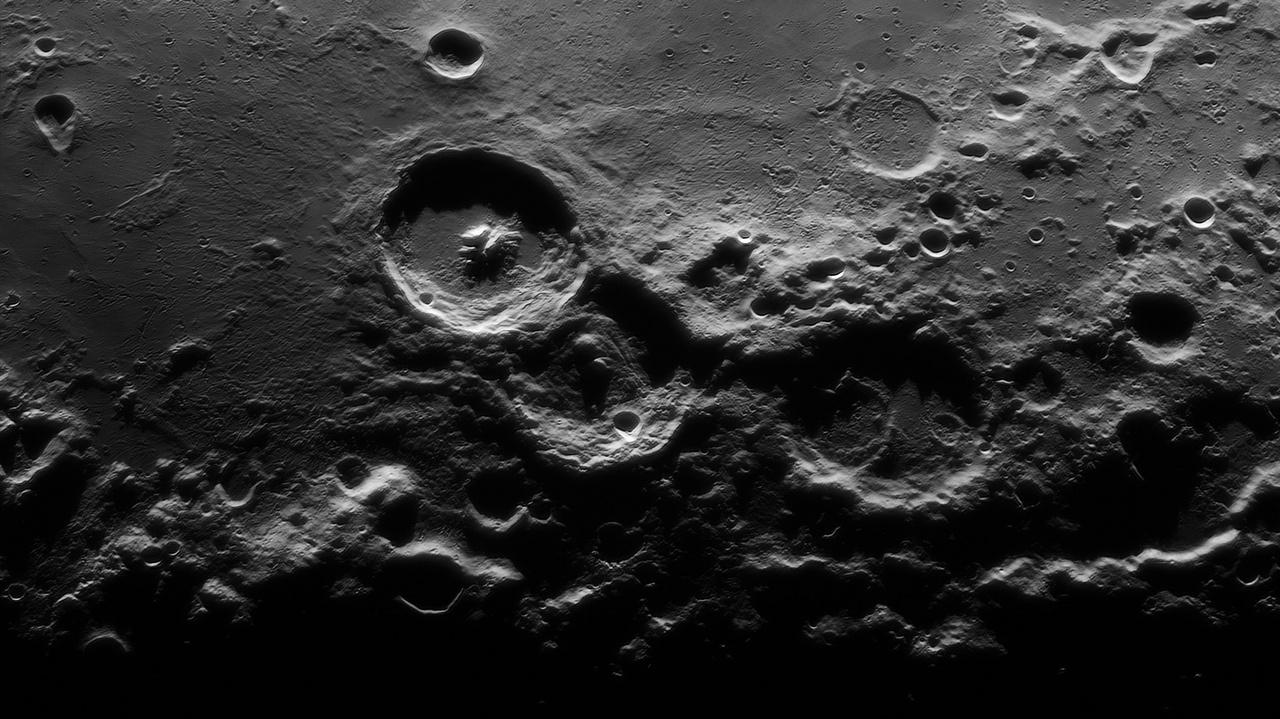 A Mesterhármas - A Hold kráterei égi kísérőnk felszínének legfőbb jellegzetességei. Az elsőre egyszerű körkörös alakzatok valójában sokszínűek, közelről szemlélve igen komplexek, és rendkívüli összetettséggel rétegeződtek egymásra az elmúlt 4 milliárd évben. Ez a különlegesen nagy felbontású felvétel drámai fény-árnyék játékkal mutatja be a Hold rideg felszínének ezt a parányi, ám izgalmas múltú régióját, a Theophilus, Cyrillus, Catharina kráterhármast.