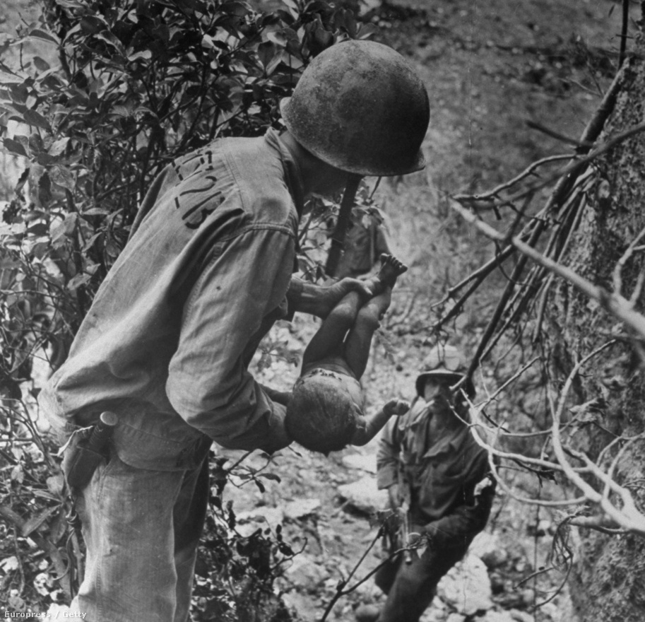 W. Eugene Smith-t a világháborús fotói tették igazán ismertté. Ezen a képen egy amerikai tengerészgyalogos egy súlyosan sérült csecsemőt ringat a második világháború japán frontján. A kis testet arccal lefelé találták egy barlangban, ahova a japánok az amerikai támadások elől húzódtak be. Smith nagyon elkötelezett fotós volt, az Okinawa-i ütközet után 12 ezer mérföldet stoppolt Guamba, hogy minél hamarabb eljuttassa a képeket a Life szerkesztőségébe, majd az első géppel repült vissza a frontvonalra