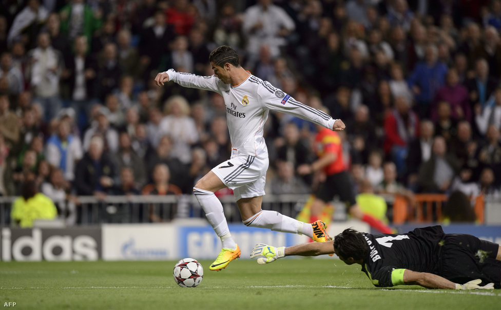 Cristiano Ronaldo tolja el a labdát a vetődő Gianluigi Buffon keze mellett a Bajnokok Ligája csoportkörében rendezett Real Madrid - Juventuson