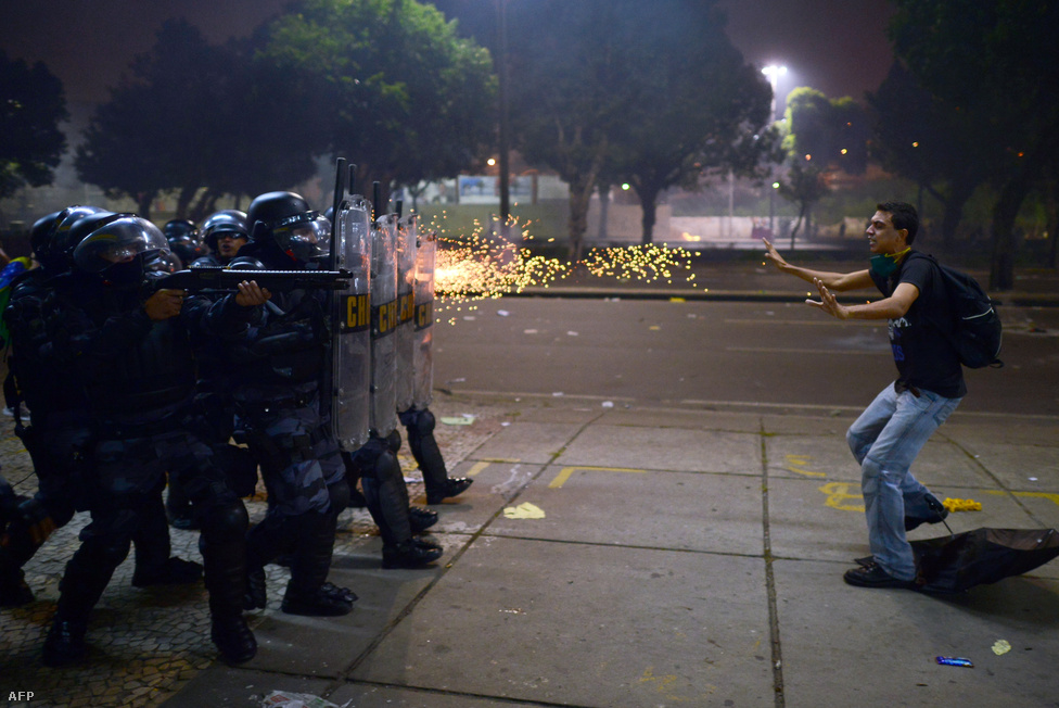 Gumilövedéket vetnek be rohamrendőrök egy tüntető ellen Rio de Janeiróban június 20-án. Brazília jövőre ad otthont a labdarúgó világbajnokságnak, így idén Konföderációs Kupát rendezhetett. Felháborította a tüntetőket, hogy az ország milliárdokat költött a Konföderációs Kupára, a 2014-es futball-vb-re, a 2016-os olimpiára, miközben a rohamos gazdasági fejlődéséért dicsért Brazíliában milliók élnek nyomorban. A tüntetők szerint nem világversenyek kellenek, hanem kórházak és iskolák. Csak a riói olimpiai előkészületek 13 milliárd dollárt emésztettek fel.