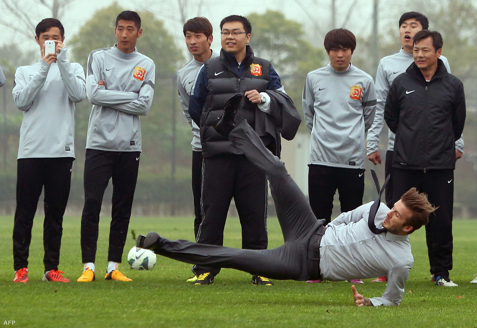 David Beckham elesik, miután megkísérelt elvégezni egy szabadrúgást a vuhani focicsapat edzőpályáján Kínában.