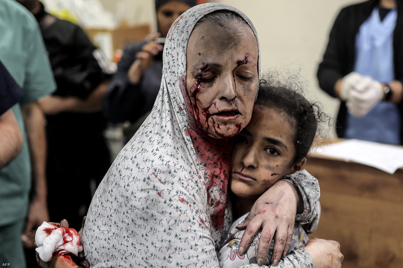 Porral és vérrel borított arcú palesztin asszony öleli egy sérült lányt az izraeli légitámadások után a Gázai övezet déli részén felvő Hán Junisz városának kórházában november 15-én.