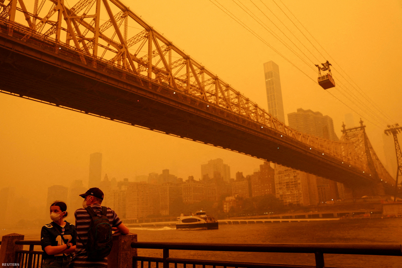 Szájmaszkot viselő járókelők New York City-ben, ahol a Manhattan fölötti eget a kanadai erdőtüzek lehúzódó füstje borítja be június 7-én.