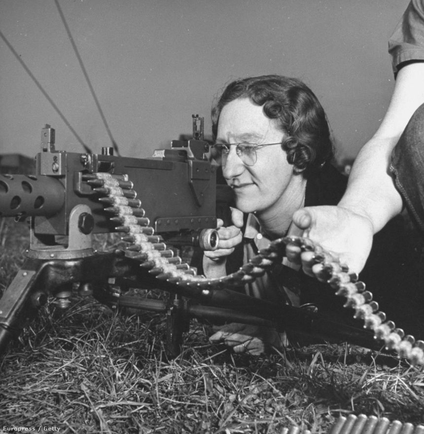 Lőni tanul egy nő egy letámasztott .30-as gépfegyverrel az Aberdeen Katonai Támaszponton. Davis nem várta meg a fronton a második világháború végét, hanem inkább otthoni környezetében fotózta a háborús gépezet hátterében dolgozókat - ami legalább olyan fontos témának bizonyult, mint maga a háború. 
