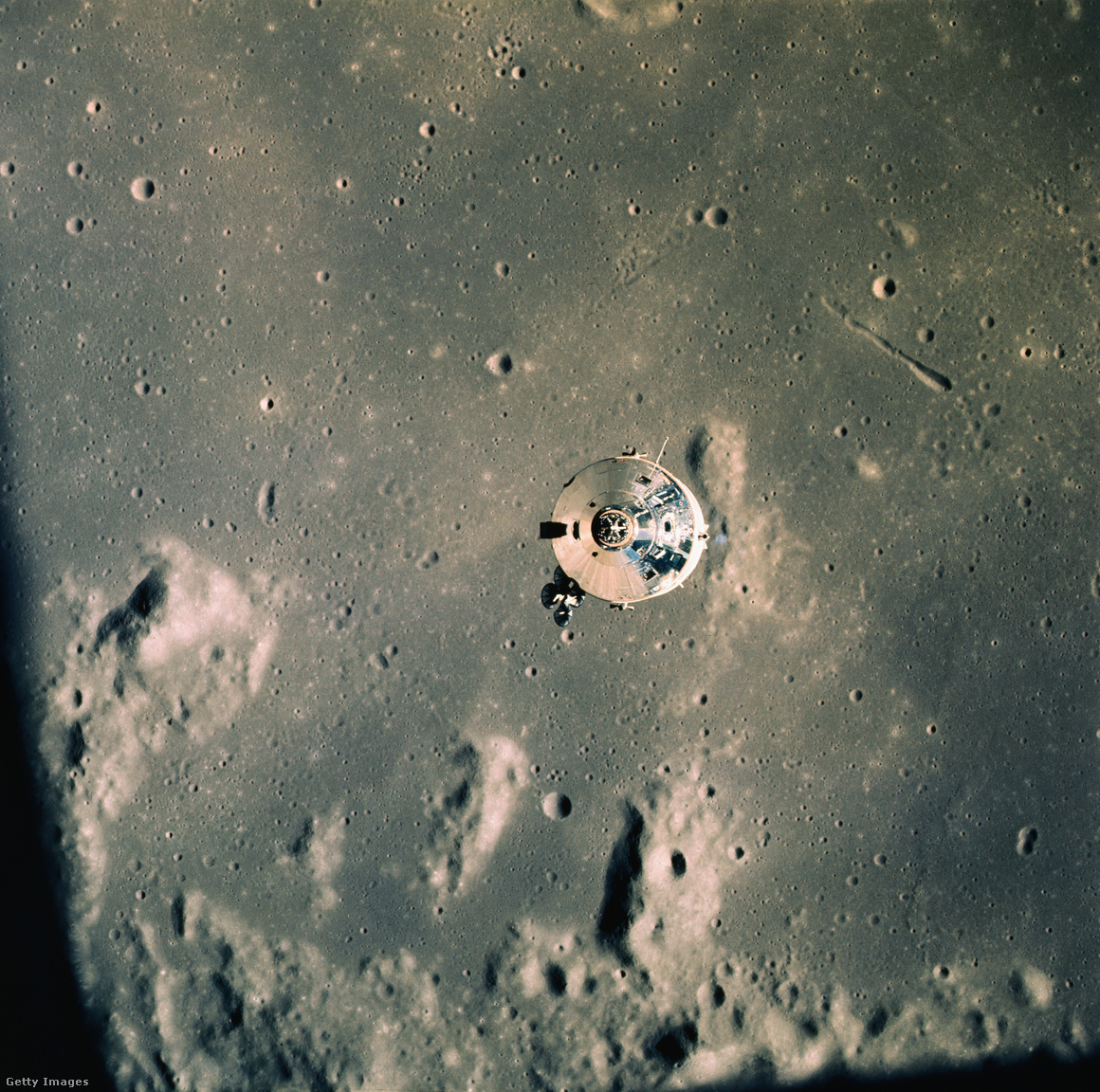 Az Apollo 11 parancsnoki modulja a Holdmodulból nézve az Apollo 11 űrrepülése során Hold körüli pályán. Aldrin és Armstrong a Holdmodulban szállt a Holdra, míg Collins továbbra is a Hold körül keringett a parancsnoki modulban. Háttérben a hold felszíne
                        