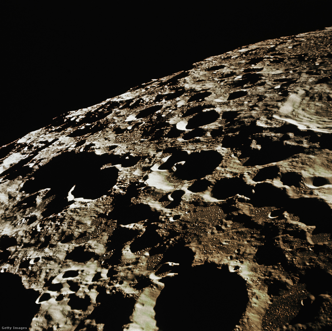 Az Apollo 11-ről készített kép a Hold távolabbi, délnyugati oldaláról. A Nemzetközi Csillagászati Unió 308-as krátere, körülbelül 58 mérföld átmérőjű, a kép szélén található nagy kráter. A fénykép közepén egy kis csúcskráter (kevesebb, mint 1 mérföld átmérőjű) egy közeli kúp alakú dombon helyezkedik el, amely két szomszédos, nagyobb kráter (körülbelül 20 és 9 mérföld átmérőjűek) közös peremén található. Ez a domb nem különbözik a Földön található salakkúpoktól, és egykori Holdvulkanizmus jelenlétére utal
                        