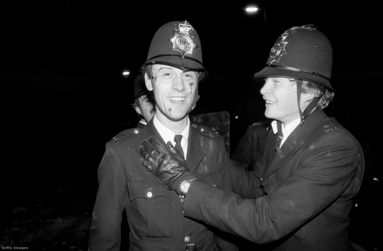 Southall, Anglia, 1981. július 4. Egy rendőr segít társának sérülései ellátásában, amit az ázsiaiak és a szkinhedek közt dúló küzdelmek elhárítása során szerzett 