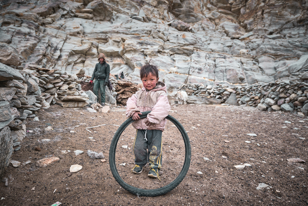 Changpa kisfiú egy bicikligumival játszik (Ladakh, 2018. február)