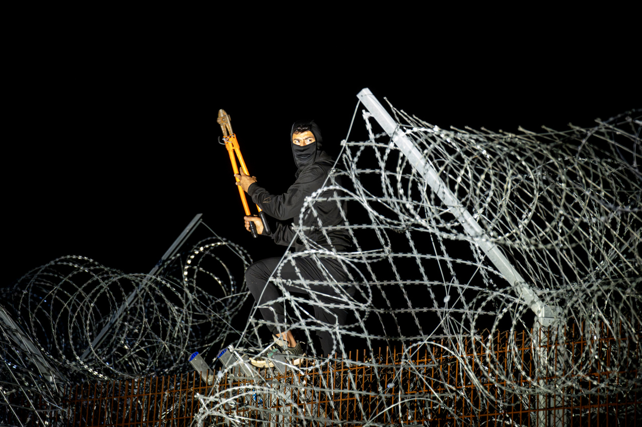 Hír- és eseményfotó kategória 3. díj: Kerítésvágó – Illegális határsértő férfi vágja át a kerítést a magyar-szerb határon lévő határzárnál 2023. szeptember 30-án
                        