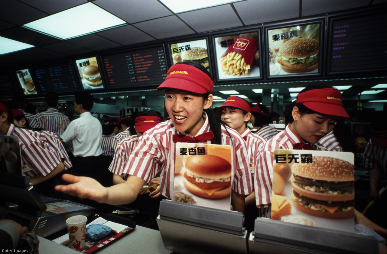 Peking, Kína, 1992. április 23. Egy pénztáros köszönti a vásárlókat a pult mögül egy McDonald's gyorsétterem nyitónapján