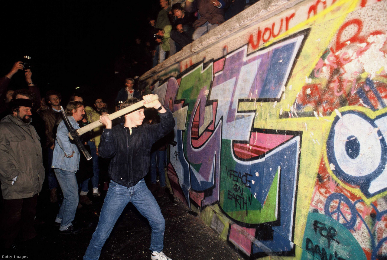 Berlin, Németország, 1989. november 9. Egy férfi csákánnyal ront a berlini falra, miután gyorsan elterjedt a hír, hogy a keletnémet kormány kiutazási vízumot ad mindenkinek, aki Nyugatra akar menni, a bejelentést ugyanis úgy értelmezték, hogy a határ mostantól nyitva áll, és a keletnémet határőrök nem tudták megállítani a falhoz igyekvő emberek rohamát, órákon belül az emberek saját kéziszerszámaikkal törték össze a fal egyes szakaszait, és ezek az első repedések a falon napokon belül a határ teljes megnyitásához vezettek