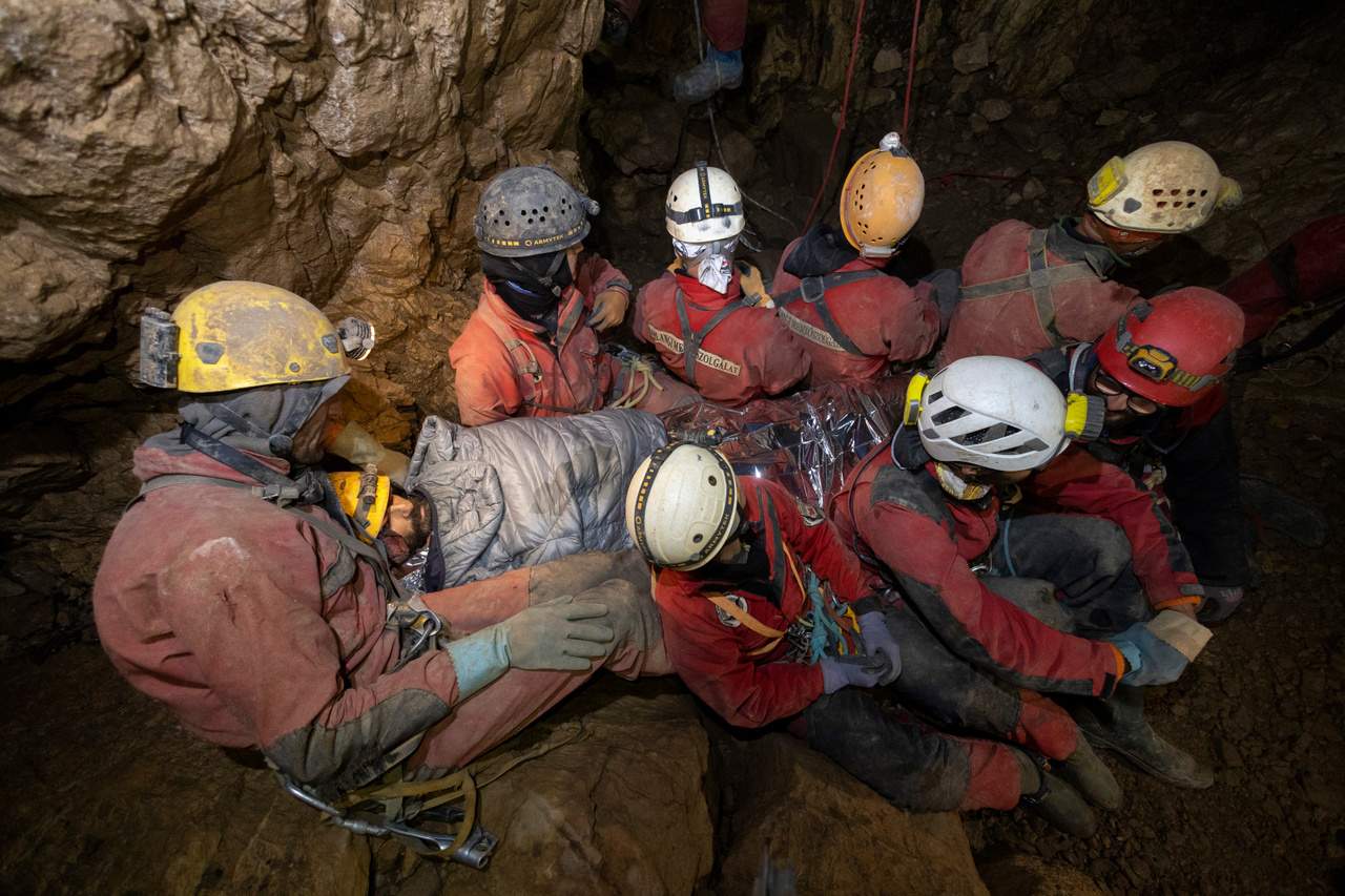 Magyar és kolozsvári barlangászok testükkel melegítik a sérültet, amég a kötélpályán elindulhat a hordágy továbbhúzása