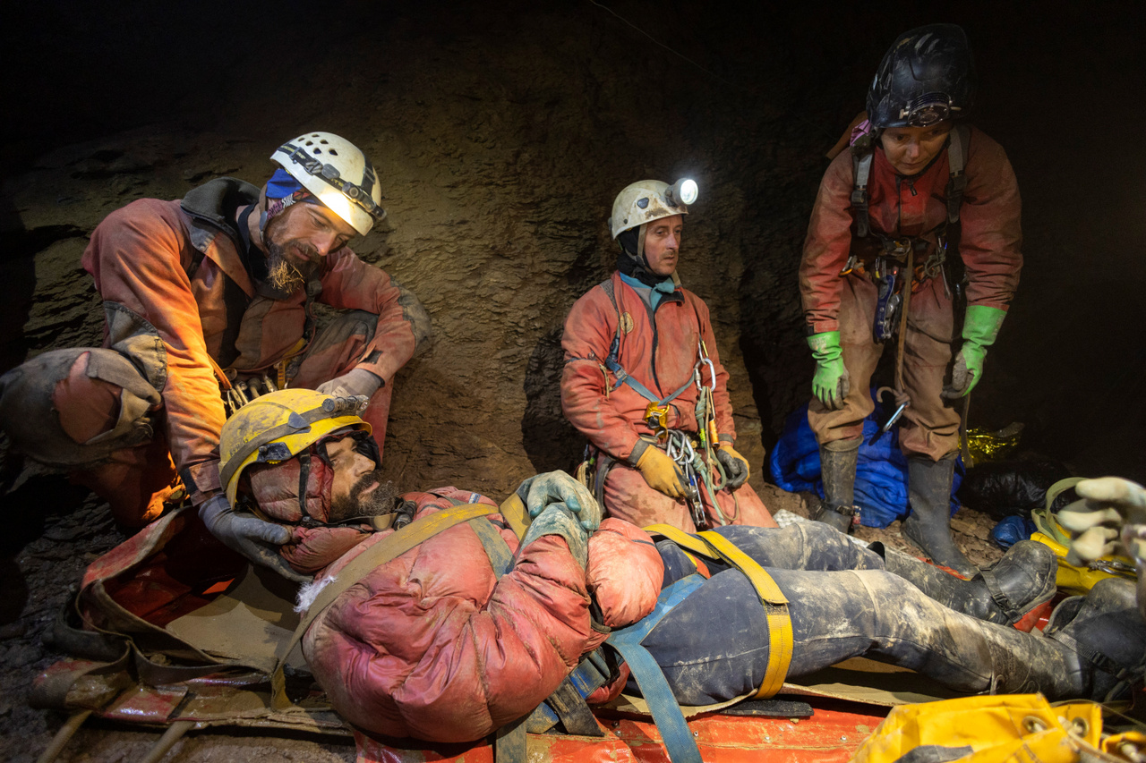 Zsigmond Peti, kolozsvári barlangász tartja Mark fejét, még párnát keresnek alá a mentősök, hogy komfortosabban utazzon a hordágyban
