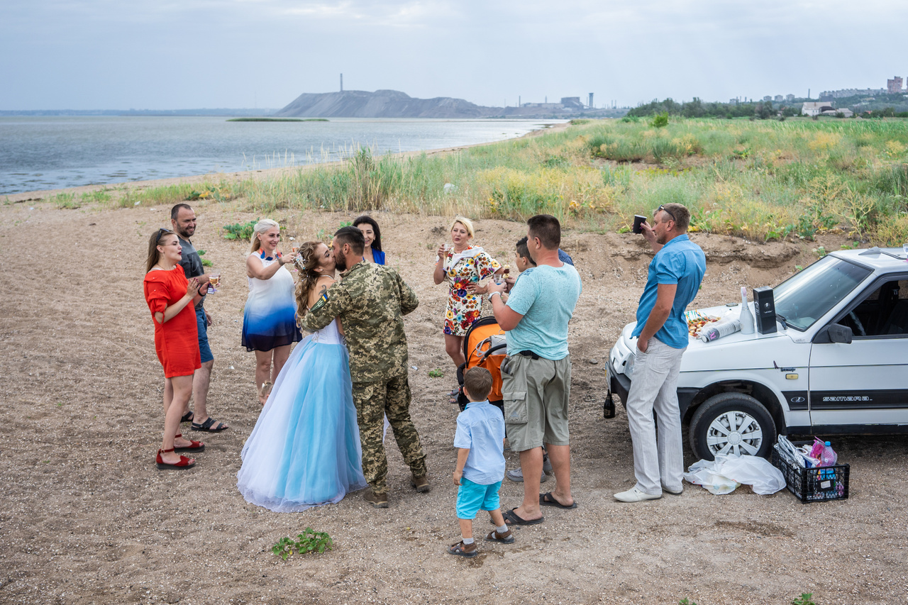 Mariupolban, az Azovstal vasmű strandjánál ünnepel két frissen házasodott pár, amelynek férfi tagjai a környéken állomásozó ukrán hadseregben szolgálnak 2019. június 12-én