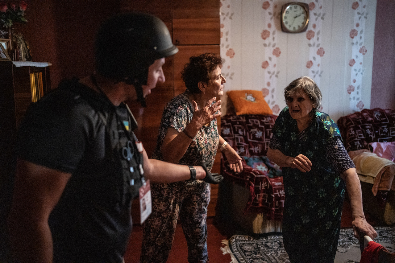 A Vosztok SOS szervezet önkéntesei menekítenek ki egy idős asszonyt otthonából a front közelében Bahmutban 2022. augusztus 20-án