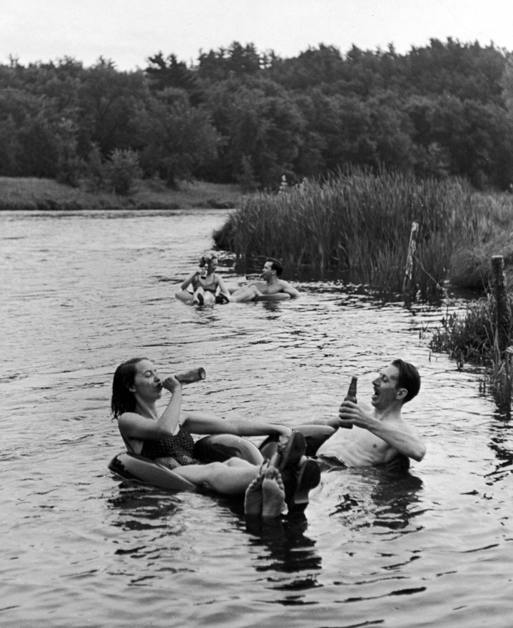 1941. Ezzel képpel egészen nyudodtan lehetne sört is reklámozni, annyira tökéletesen visszaadja egy forró nyári nap léhaságát és egy hideg sör élményét. A fotó 1941-ben készült, a gumibelsőben söröző pár az Apple-folyón sütteti a hasát.