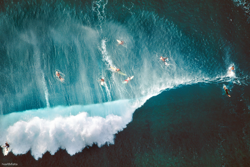 Szörfösok a méteres hullámok között a hawaii Oahu-strandon.